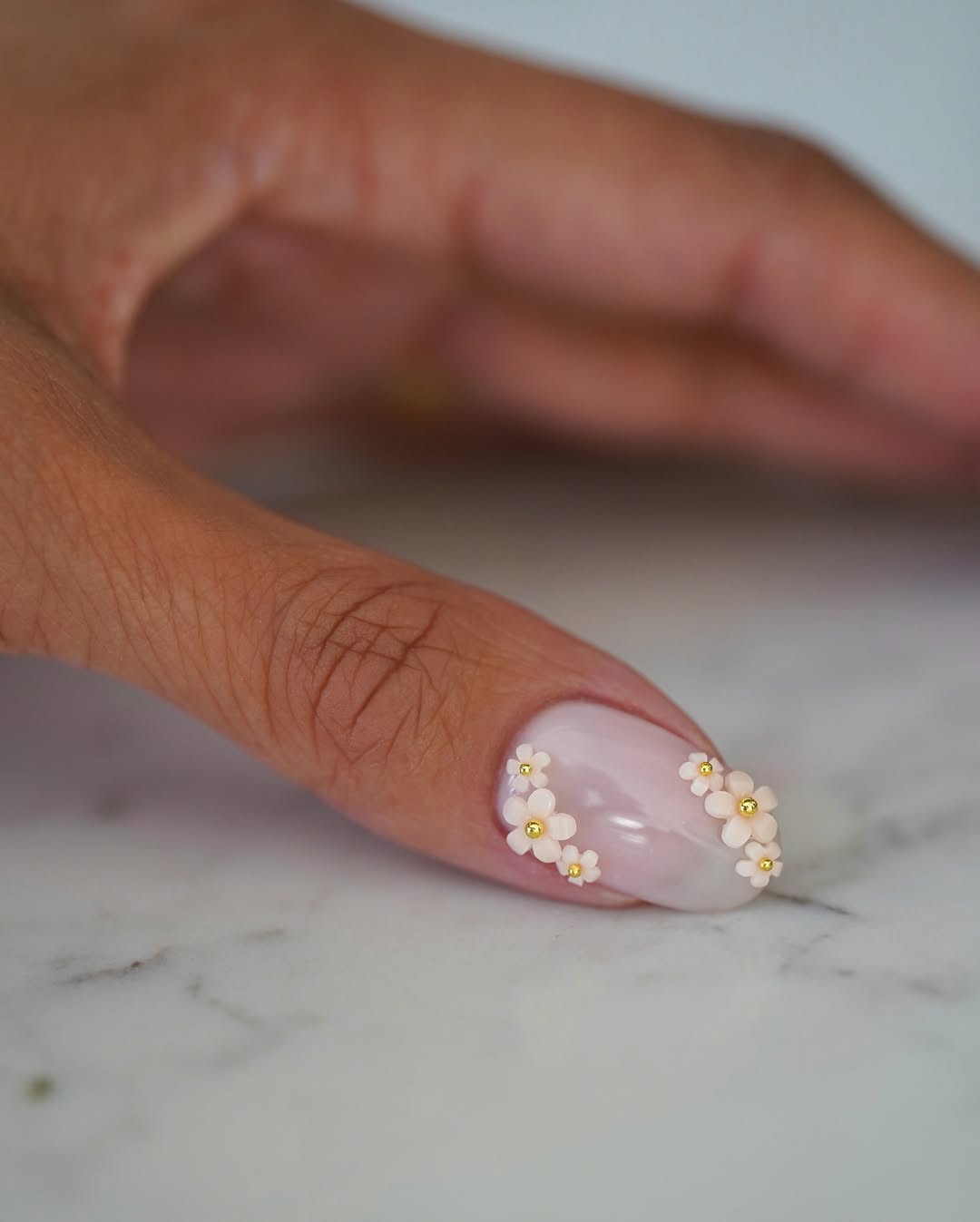 A milky manicure with 3D flower details by Iram Shelton