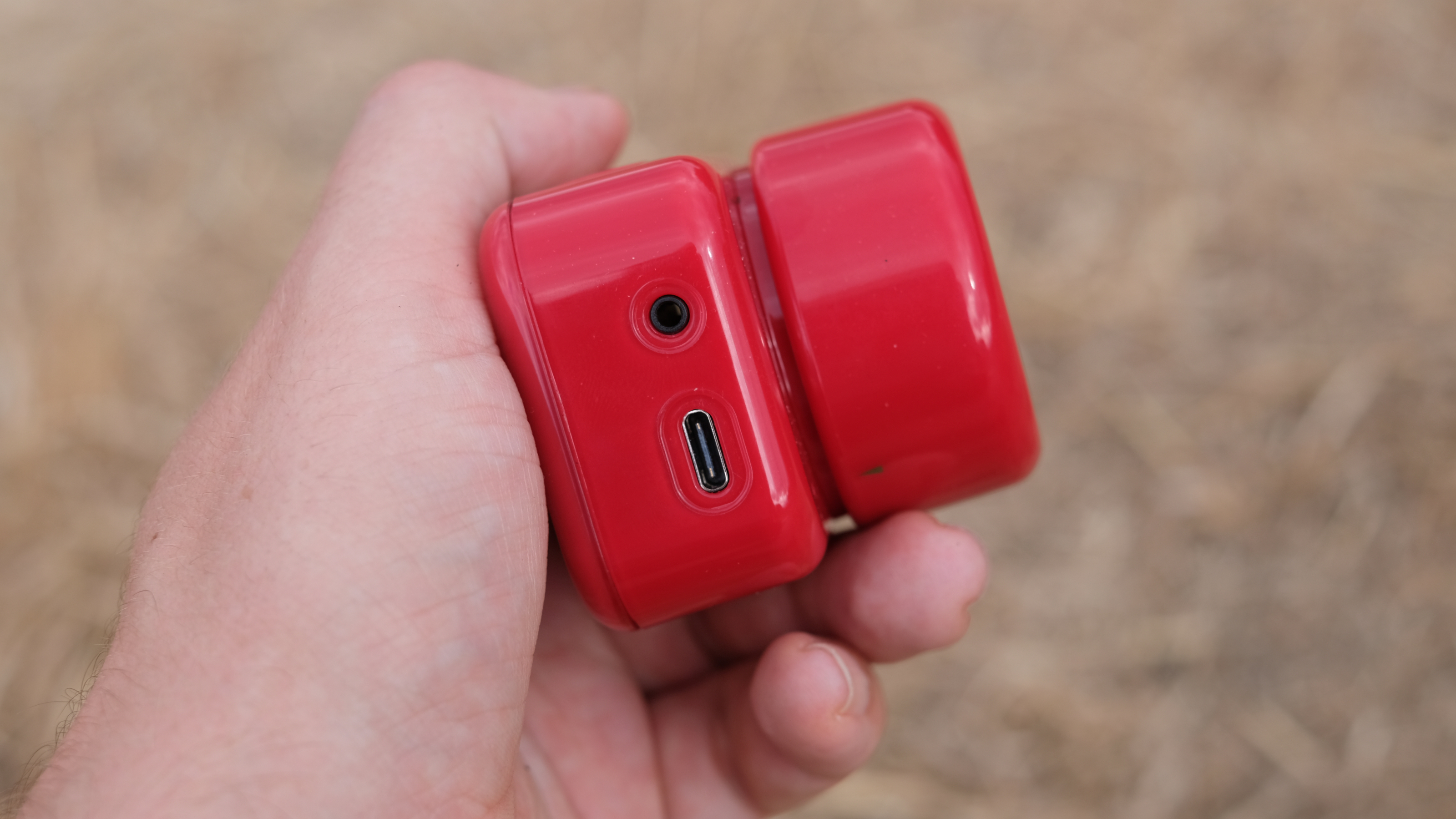 Photograph of the ATLi Eon time-lapse camera in red, side view with USB-C port and 2.5mm jack