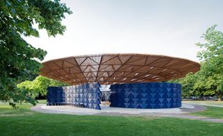 Outdoor pavilion with blue curved walls and brown circular roof