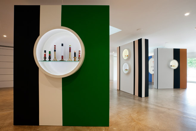 Green stand with beige stripe and art sculptures in the middle