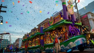 A parade float pictured with guests throwing beads at Universal Studios Florida.
