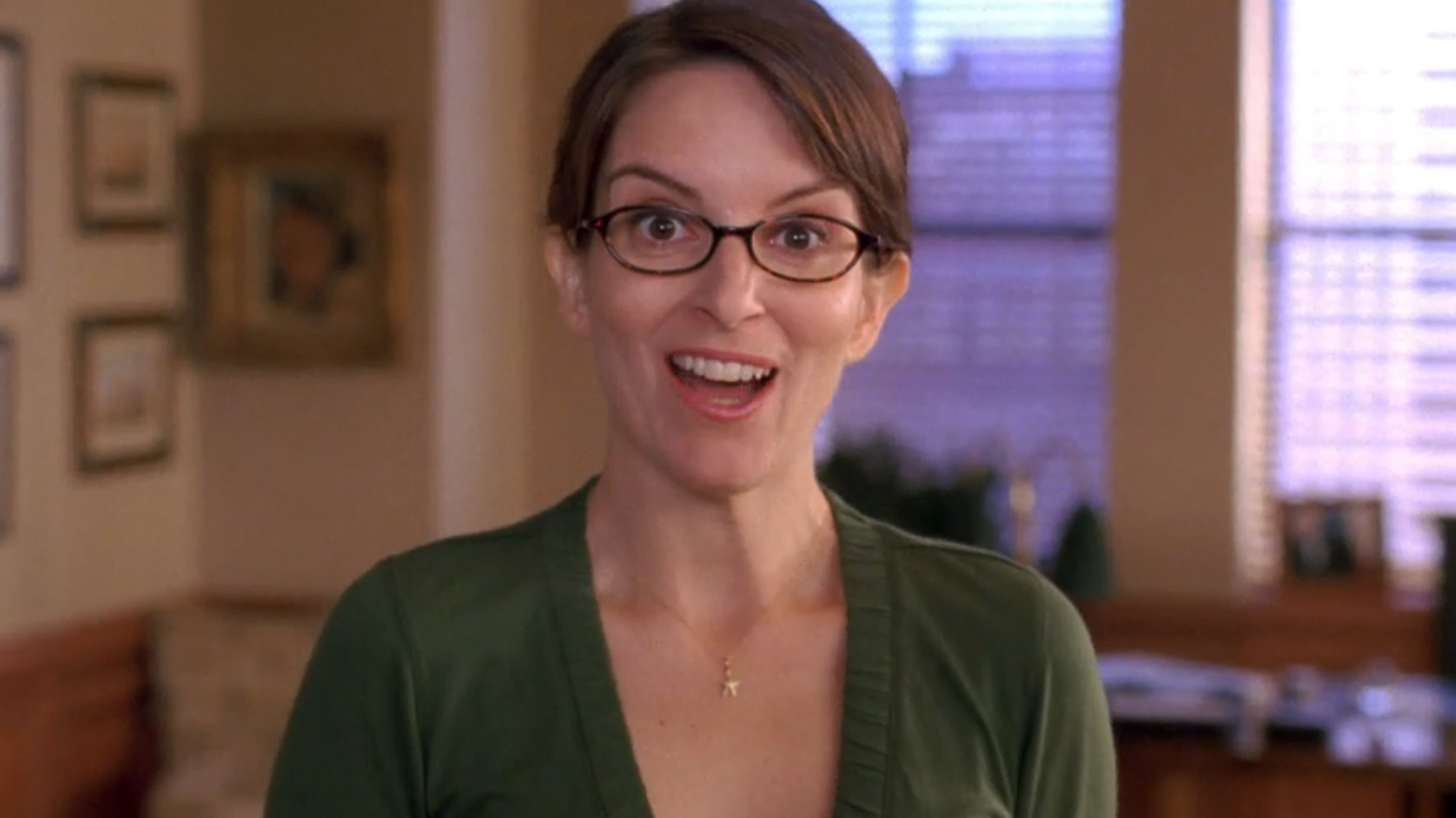 Tina Fey with a big smile, looking at the camera in 30 Rock