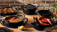 Le Creuset Alpine Collection on a wooden outdoor table. 