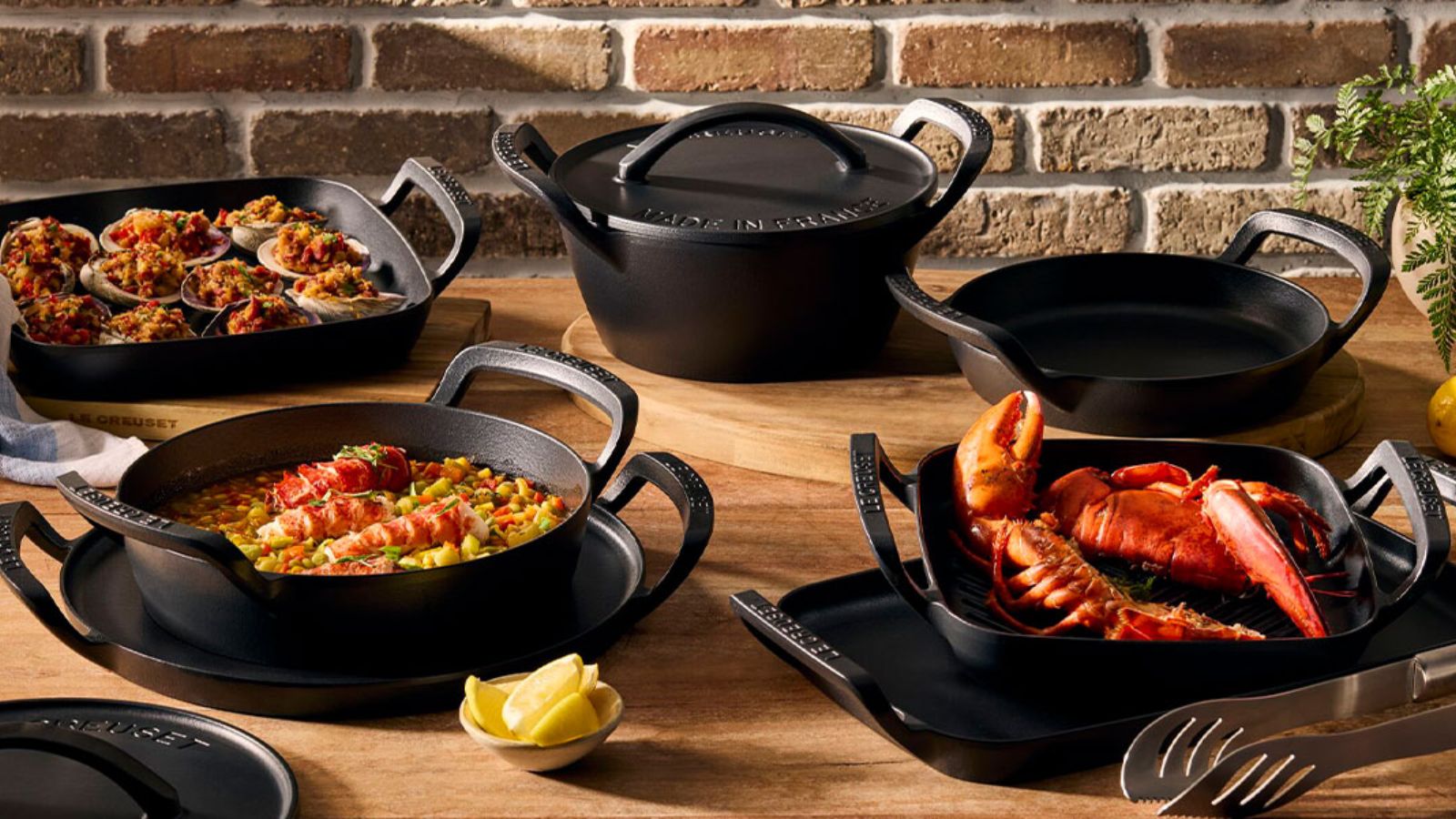 Le Creuset Alpine Collection on a wooden outdoor table. 
