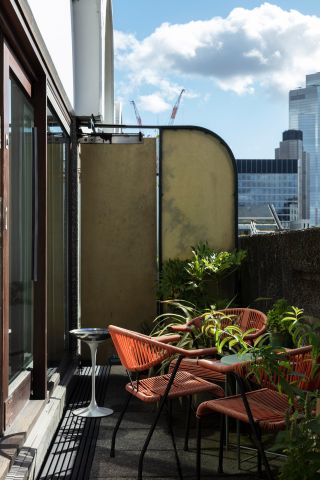 Terrace of Barbican apartment with orange chairs and green plants