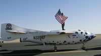 man stands on top of plane and holds the american flag