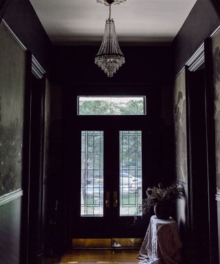 black entryway with double doors and chandelier