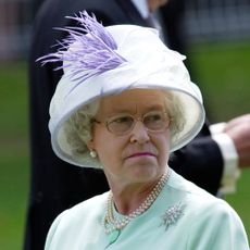 Queen Elizabeth wearing a mint coat and hat and grimacing