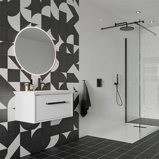 bathroom with black and white patterned tiling and white round mirror on wall