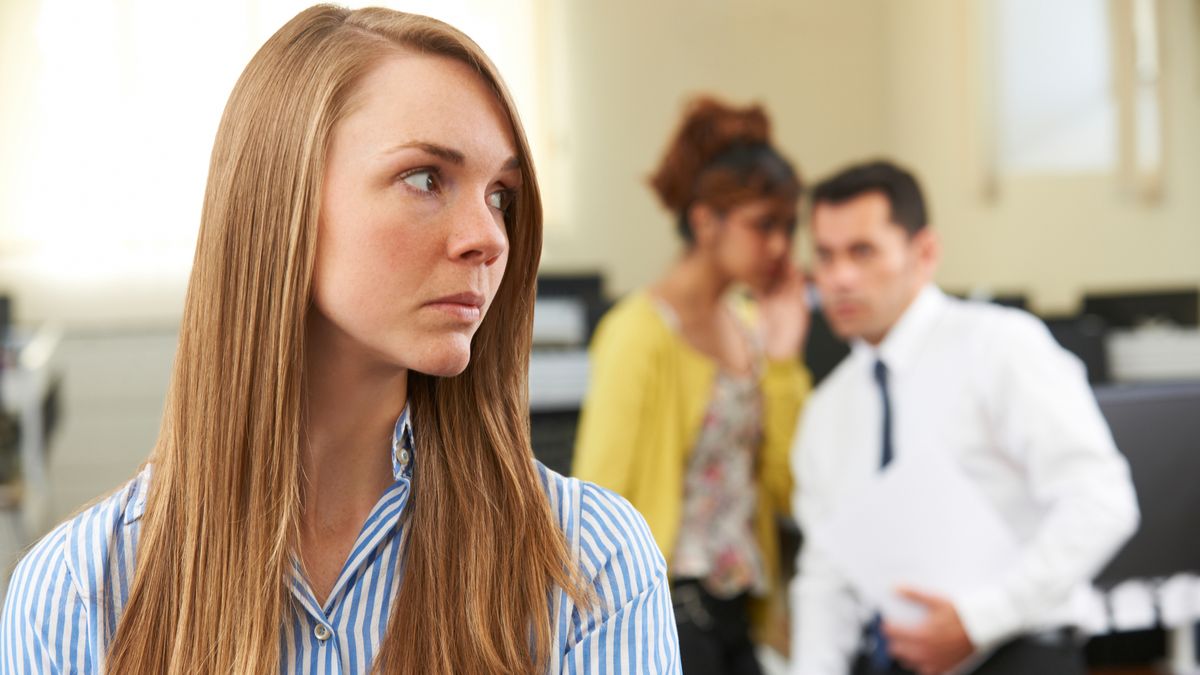 Businesswoman Being Gossiped About By Colleagues In Office