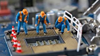 a group of workers looking down at a cpu socket