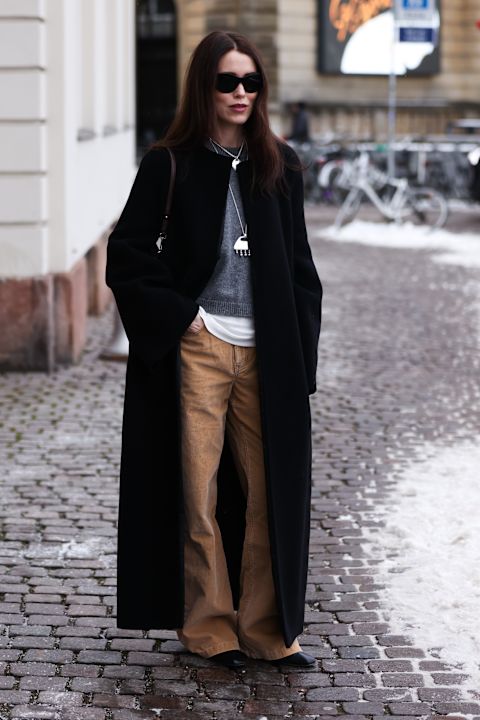 woman wearing brown pants, gray sweater, black jacket Copenhagen