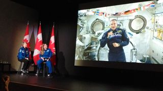 Canadian astronaut David Saint-Jacques (on screen) speaks to students in Ottawa, Canada Jan. 22, 2019 from the International Space Station while in conversation with fellow astronauts Roberta Bondar (far left) and Jenni Sidey-Gibbons (center).