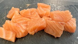 Salmon cortado en dados para cocinarlos en la freidora de aire