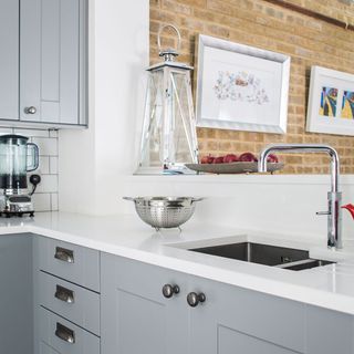 kitchen with white counter grey cabinets and wash basin