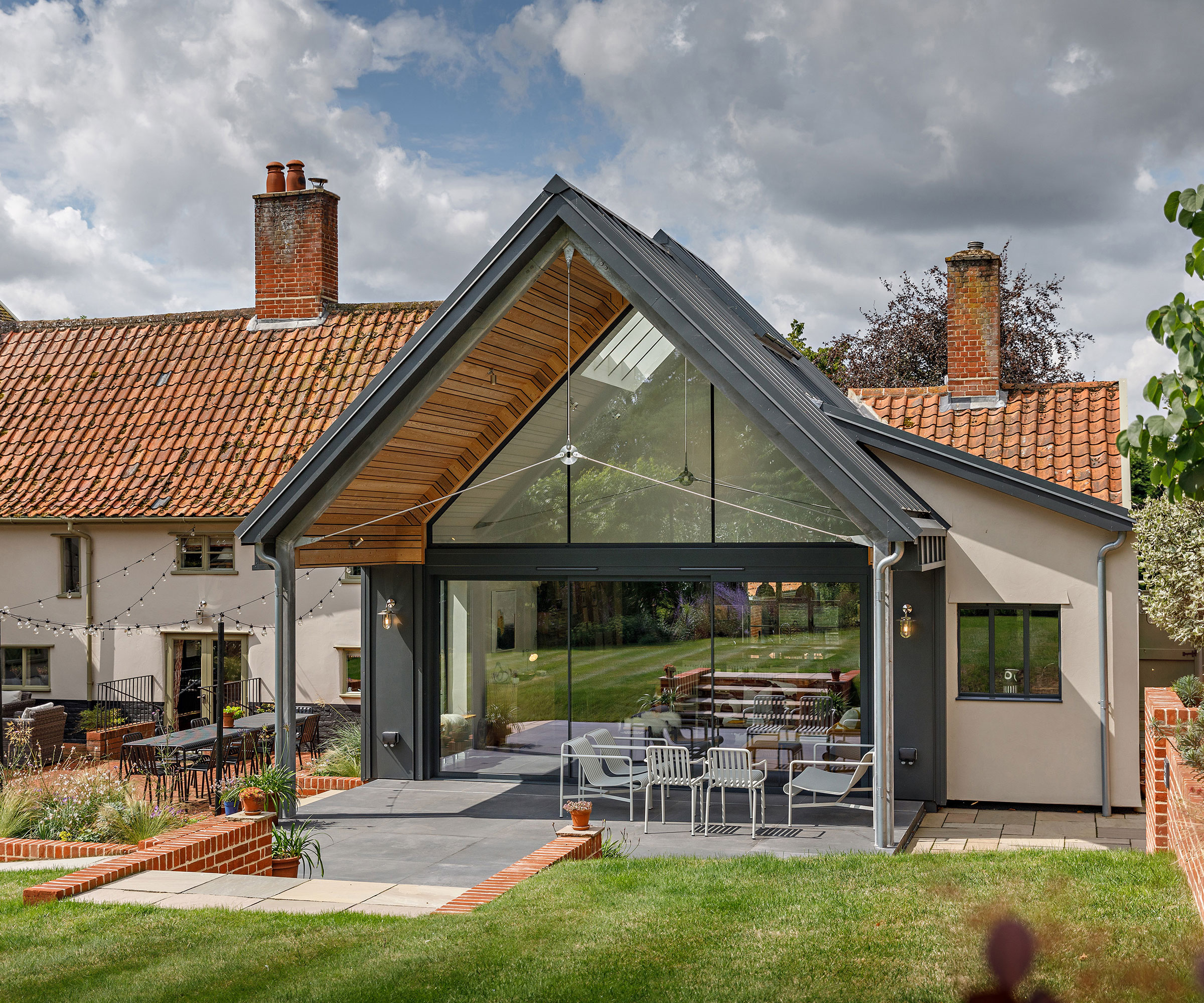 period cottage with a modern extension with a fully glazed end wall showcasing contemporary sliding glass doors