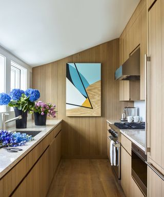 wood kitchen with modern art and steel appliances