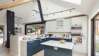 dark blue kitchen with vaulted ceiling and spotlights