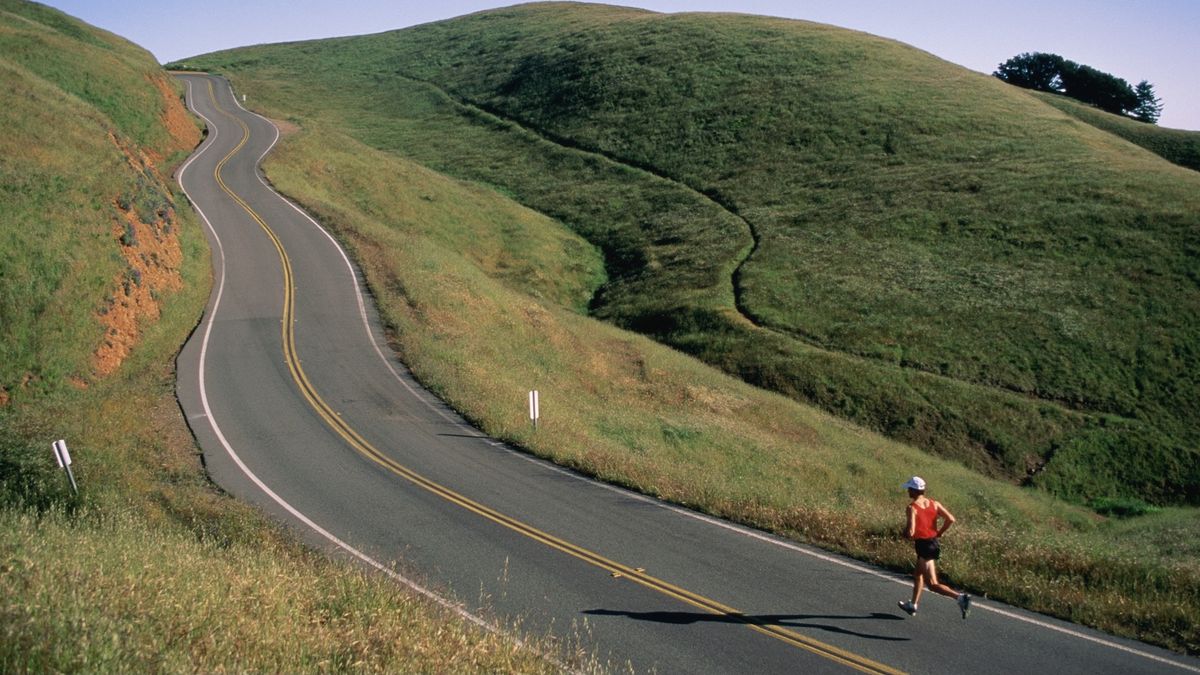 Person running on winding hilltop road