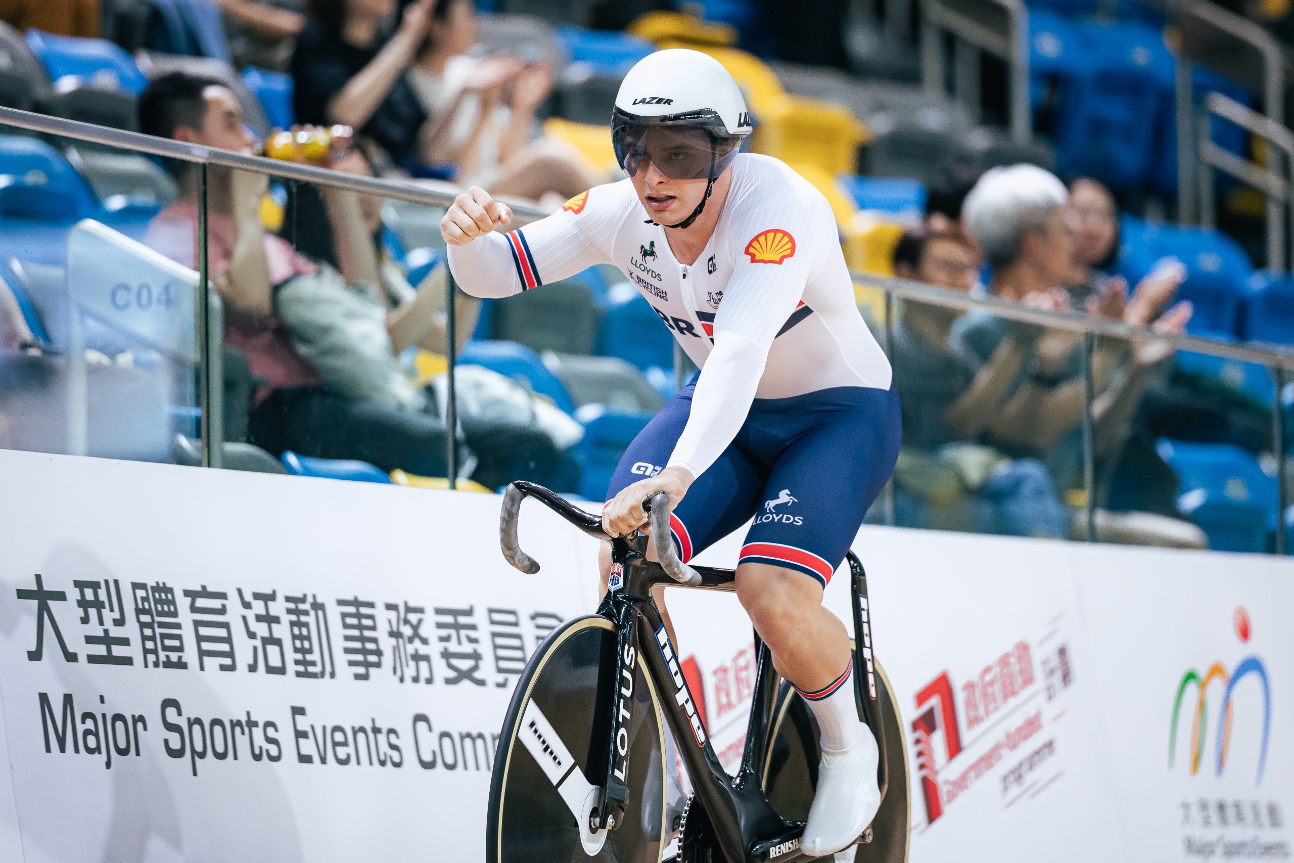 Matthew Richardson punching the air while riding on the track for Great Britain