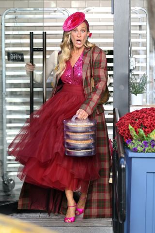 A photo of Sarah Jessica Parker in a pink sequin top, plaid coat, and red tulle skirt.