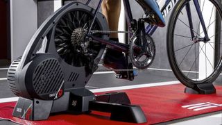 A cyclist riding on a smart trainer in a garage