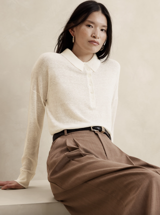 a model sits in front of a plain backdrop wearing a banana republic linen top and a pair of khaki pants