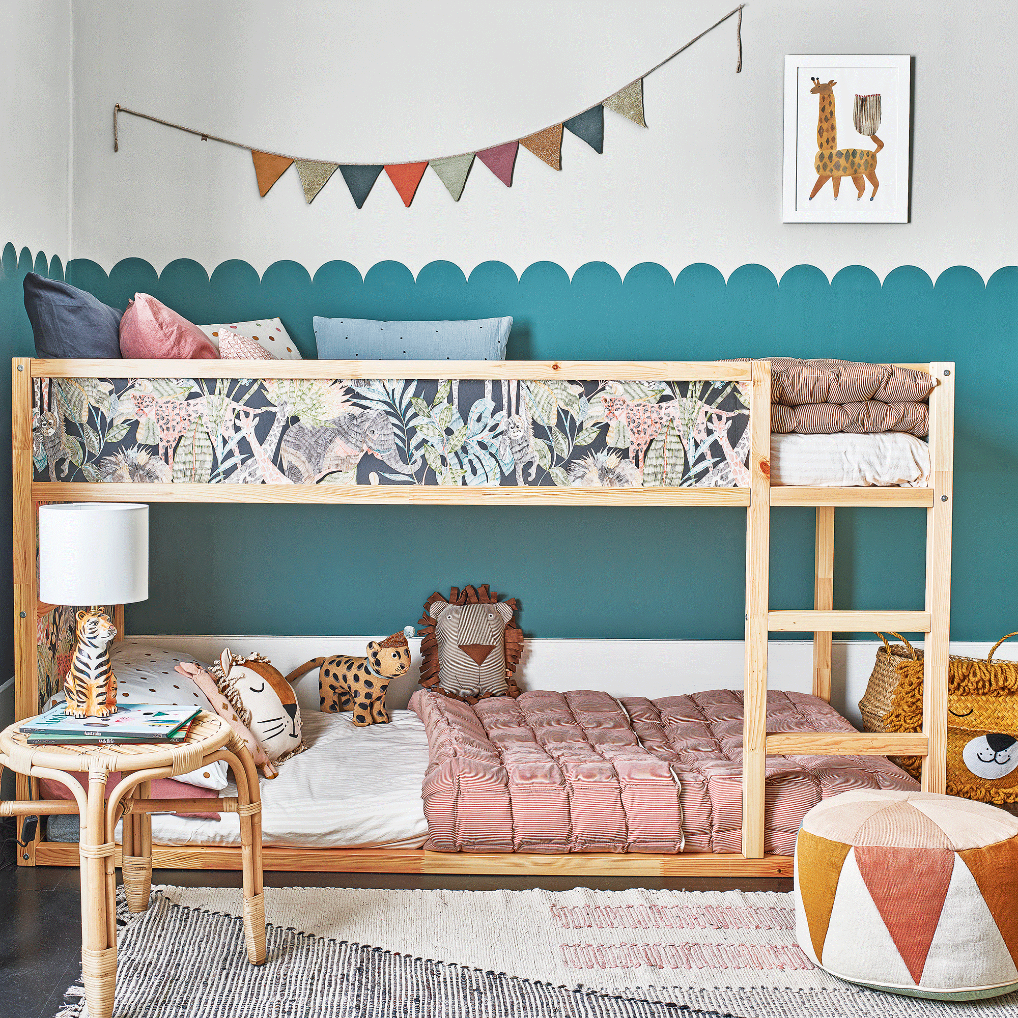 Bunk bed with teal scalloped wall and wooden side table