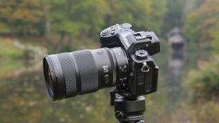 Nikon Z 24-70mm f/2.8 S II lens mounted to a tripod with autumnal lake background