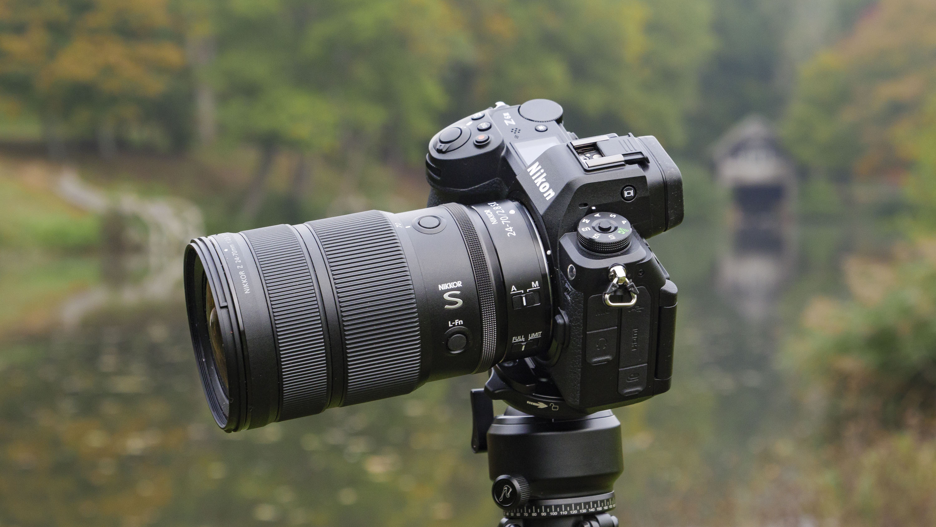 Nikon Z 24-70mm f/2.8 S II lens mounted to a tripod with autumnal lake background