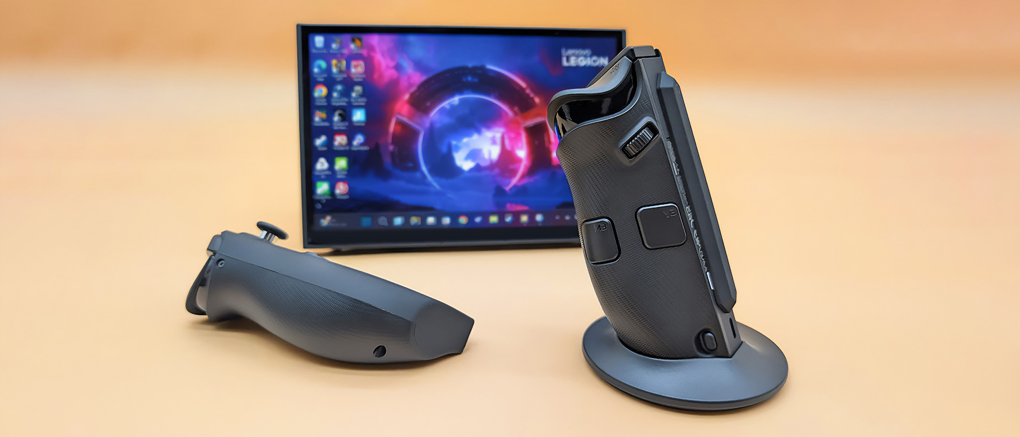 The Lenovo Legion Go 2 right controller in its FPS mode base with the let controller lying down. The Legion Go 2 is propped up on its kickstand behind them. 