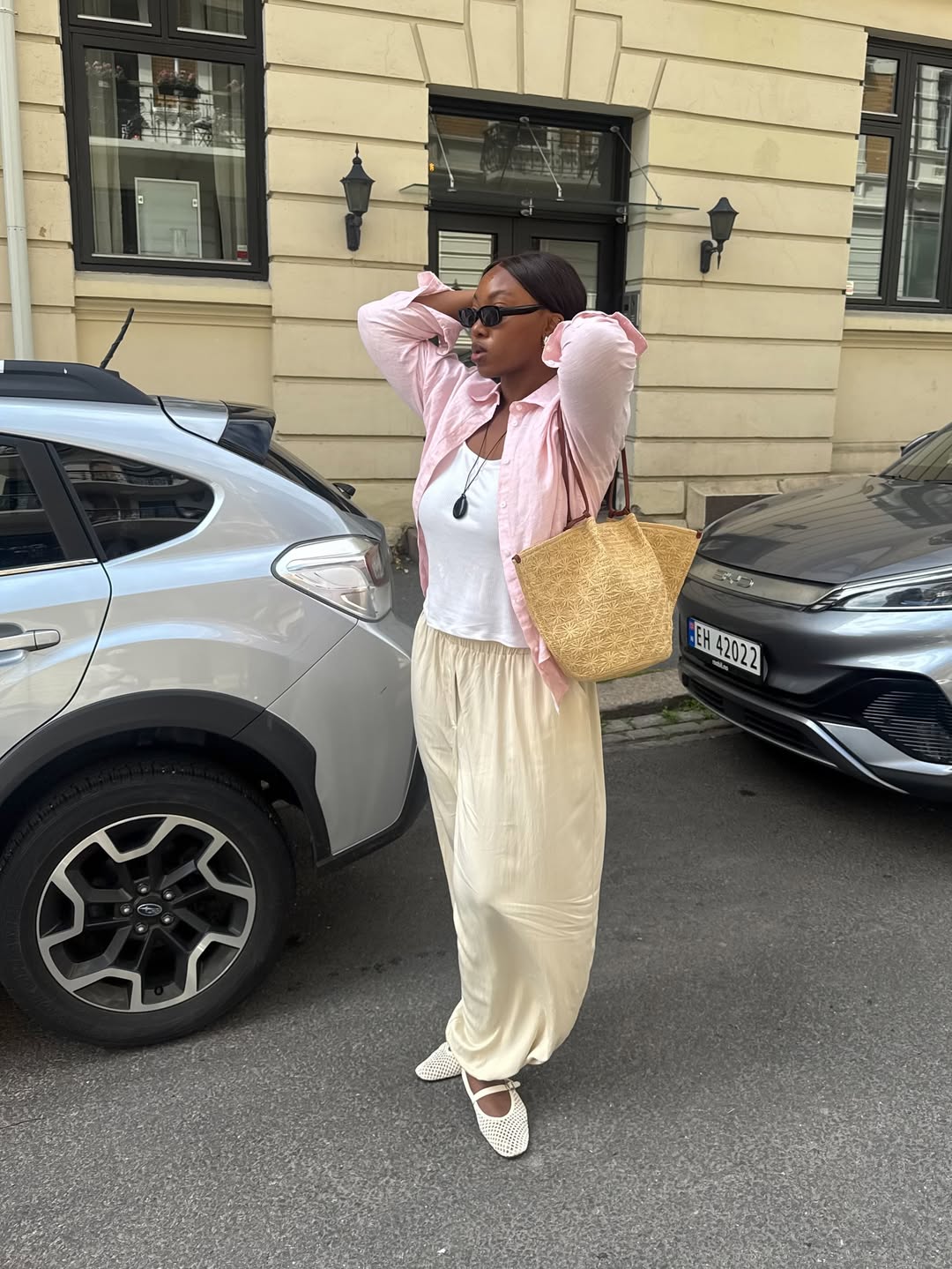 @nnennaechem wears yellow harem pants, white tank top, pink shirt