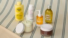 A collection of products available at LOOKFANTASTIC on a blue and cream pinstriped background.