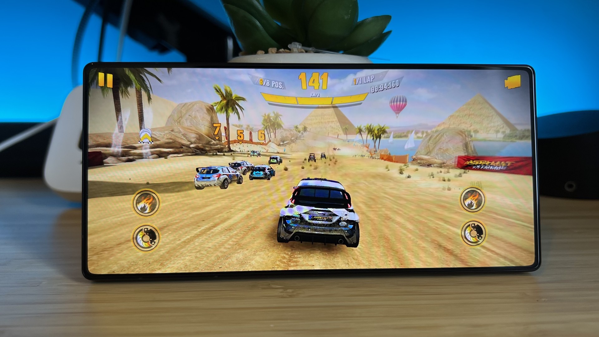 RedMagic 11S Pro gaming phone playing Asphalt Xtreme on a wooden desk with blue backlighting