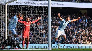 Ruben Dias scores for Manchester City against Liverpool in November 2023, but the defender's effort is ruled out by VAR for a foul on goalkeeper Alisson Becker.