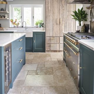Blue Shaker kitchen with light stone flooring