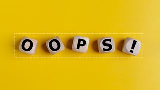 The wooden cubes with the word oops on a yellow background.