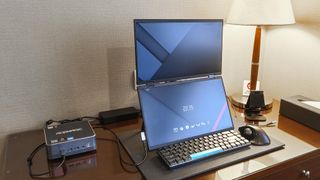 A mini PC with a portable monitor set up in a hotel room