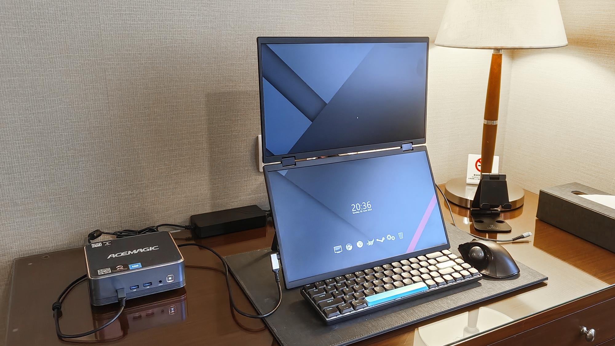 A mini PC with a portable monitor set up in a hotel room