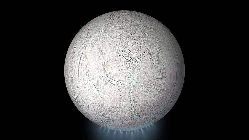 A photo of the moon Enceladus with a blue plume of steam underneath it as it sits in the darkness of space