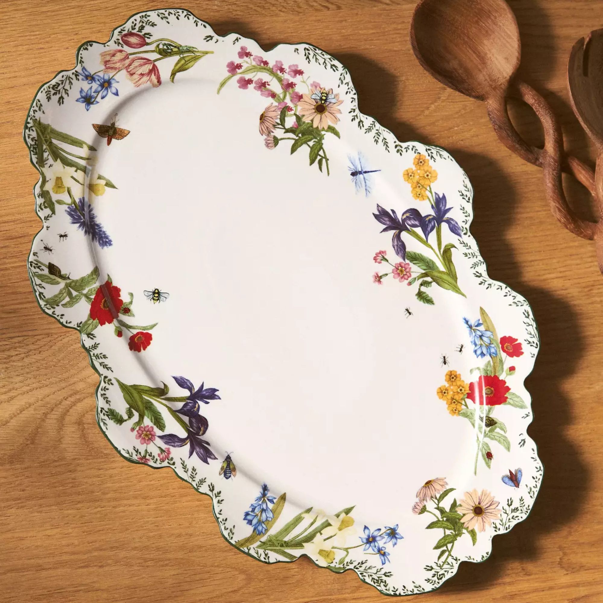 White stone platter with scalloped edges and a colorful floral design