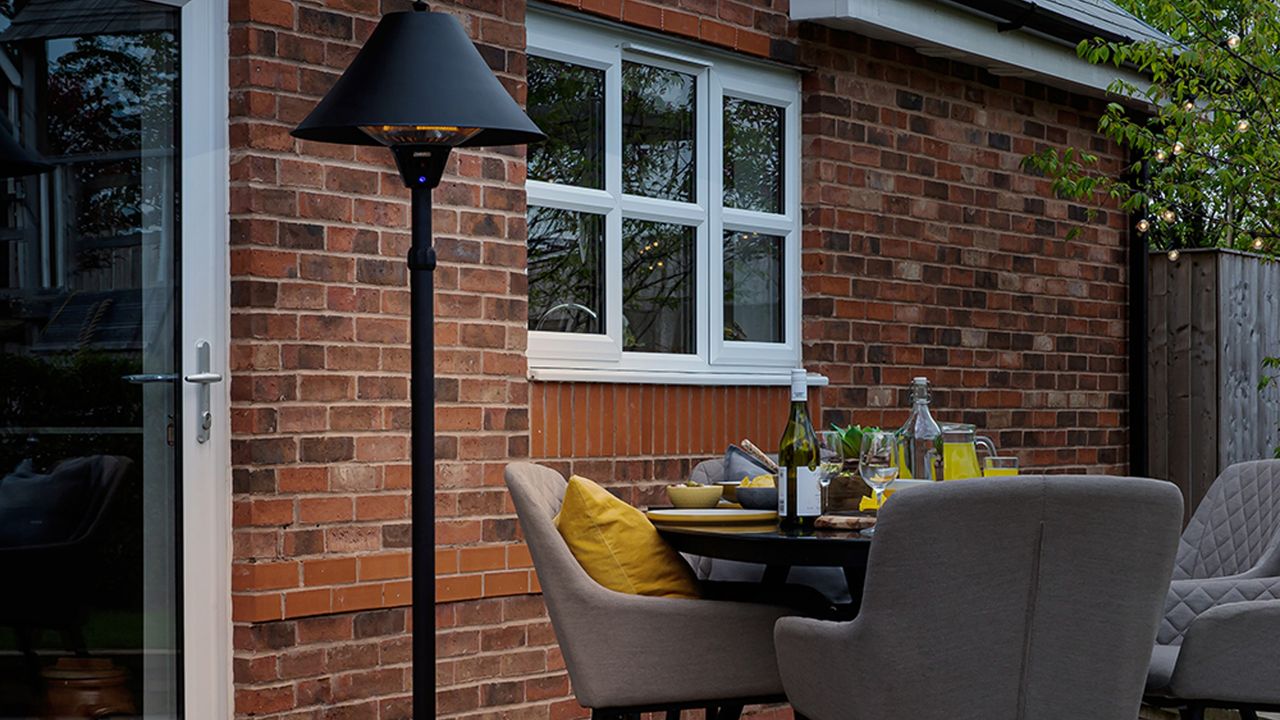 Zanussi 2100W Black Adjustable Freestanding Patio Heater in a garden with table and chairs