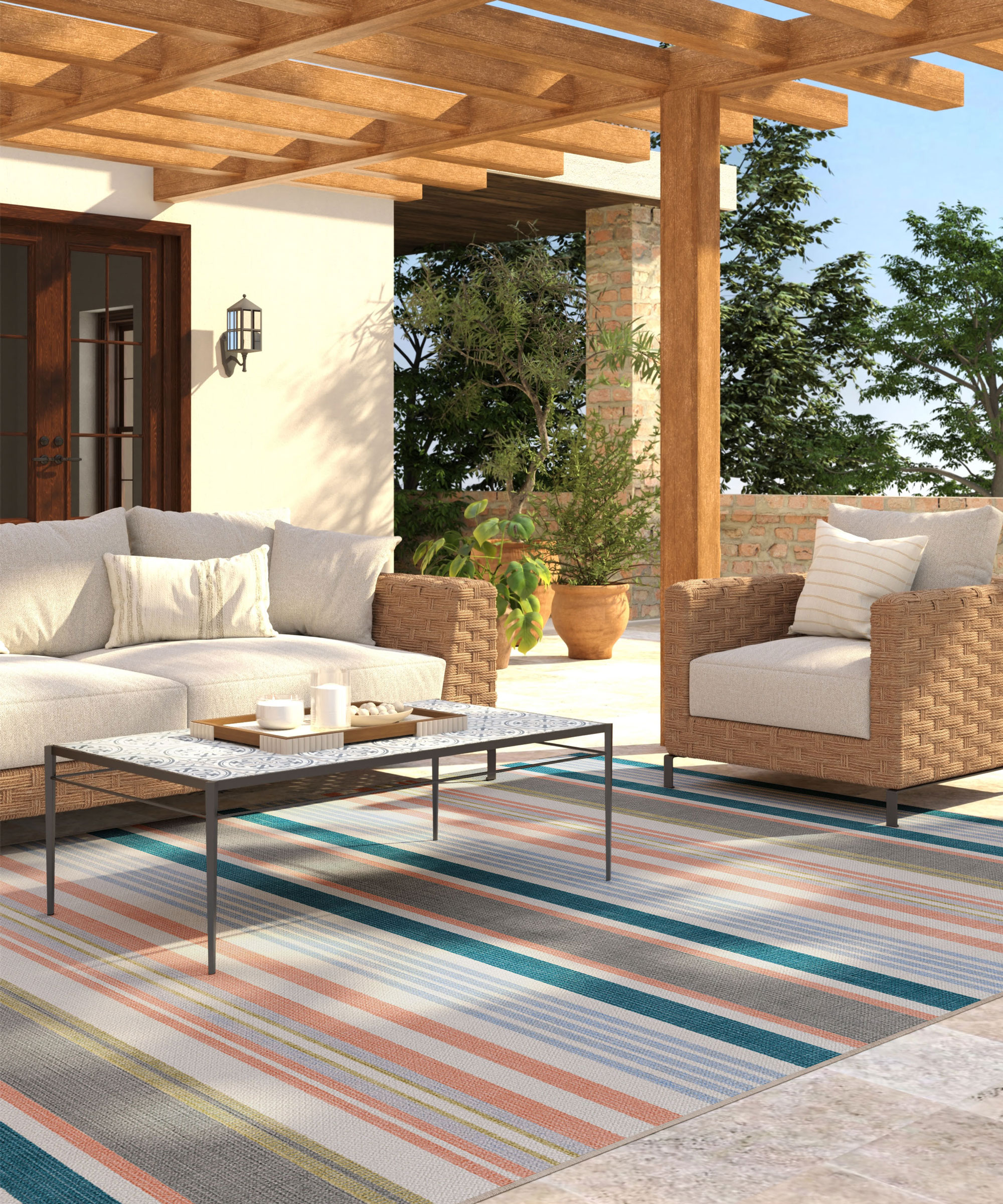 patio with wooden pergola and garden furniture including sofa and chair with coffee table and rug, plus planters and trees in the background