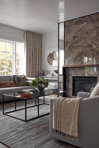living room with neutral colors gray curved sectional sofa marble fireplace