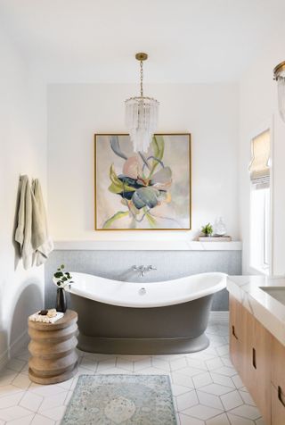 White bathroom with grey bathtub and large framed wall art