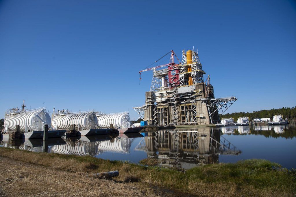 NASA&#039;s Space Launch System core booster for the Artemis 1 mission around the moon (seen in orange) stands atop the B-2 test stand at the Stennis Space Center in Mississippi for an upcoming engine test.