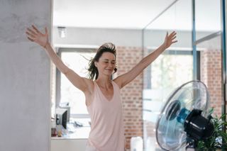 Woman cooling down in front of a fan