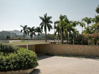 casa das palmeiras with its minimalist, low, white forms, curved openings and indoor/outdoor relationships in sao paulo's warm climate lifestyle