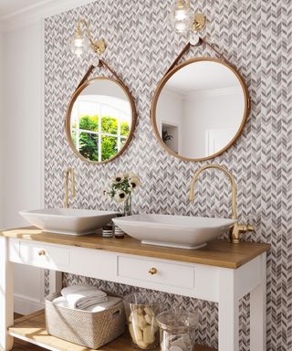 A tiled bathroom with double sink and two round mirrors