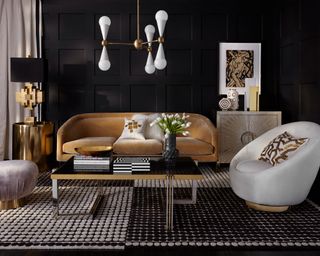 A black living room with leather sofa and statement lighting.